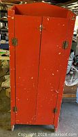 Front view of red wooden cabinet with doors closed