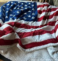Overall view of one US flag fleece throw, showing pattern and sherpa backing