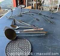 All items together on table: utensils, trivet, candelabra