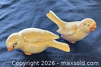 Both Mount St. Helens ash bird figurines side by side on dark cloth
