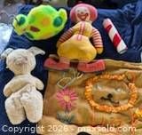 Group shot of all five items: Ronald McDonald doll, green snail plush, cream bunny, red-white kaleidoscope, burlap art