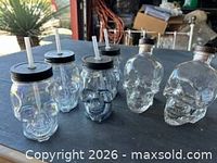 Group shot of five skull sipper jars and two Crystal Head bottles