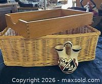 Group shot of wicker basket, wooden tray atop, ceramic wedding vase in front