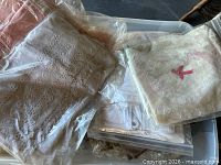Assorted white eyelet linen and lace-trimmed items bagged in tote