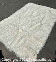 Full view of rectangular white faux fur fabric laid flat