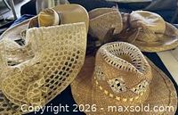 Group of four natural-tone straw hats showing overall variety