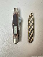 Old Timer knife and striped pen knife closed, side view showing Old Timer shield