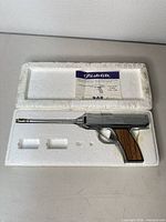 Styrofoam case opened showing lighter, barrel, instruction sheet