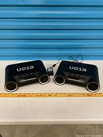 Both Eton Rukus RK100 units side by side with adapter and ruler for scale