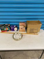 All items lined on table: NOMA lights box, media envelopes box, mason jar light box, Plow & Hearth carton, rope light coil