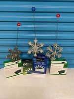 Front view of three snowflake ornaments and four boxed light sets