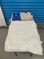 Tablecloth folded on table with folded snowman blanket atop