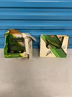Two Ertl John Deere toy boxes showing combine package and separate header set