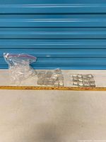 Full lot showing bag of cylindrical containers and rows of square boxes