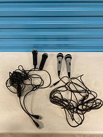 All four microphones with attached cables and Logitech USB adapter visible on table