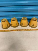 Four clip-on shades lined up front view with ruler for scale