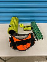 Lot overview showing foam roller, belt, rope, tube box, tennis ball