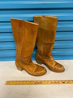 side view of both boots showing color, stitching, overall wear, and measuring tape for scale