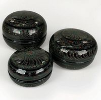 Three round carved lacquer boxes grouped together