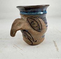 left side showing protruding nose and eye carving