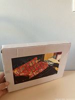 Sealed white box with product photo of ribs on rack