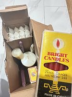 Lot showing unopened Bright Candles box, open box with assorted tealights, pillars and tapers