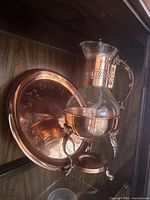 Set showing carafe on warming stand in front of copper tray
