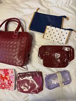 All eight cosmetic bags displayed on surface