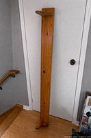 Full view of the wooden shelf unit standing upright showing top shelf and base