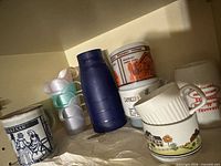 Shelf view showing mugs and plastic cups