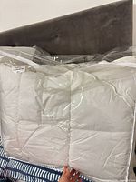 Front view of white king duvet inside clear carry bag