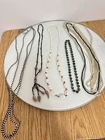 All eight necklaces laid out on tray