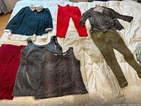 All eight stretch clothing items laid out on bed