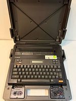 Canon Typestar 5 electronic typewriter open in case showing keyboard, display, ribbon cassette