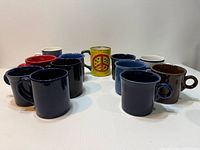 Assorted mugs arranged in circle showing color variety and novelty peace-sign mug