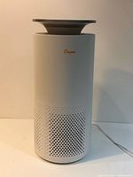 Front view of Crane cylindrical air purifier showing perforated intake and power cord