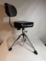 Side view showing seat, backrest, tripod base