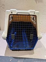 Front view of blue plastic crate with wire door closed