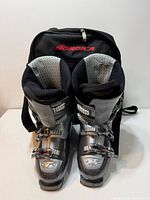 Front view of both Nordica Easy Move 12 ski boots standing inside Nordica carry bag