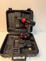 Drill standing in open molded case, interior compartments visible