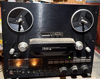 Front view showing entire TEAC X-700R deck, reel hubs, controls and meters.