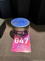 Jar with numbered card for scale showing blue enamel lid