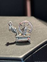 Front view of sterling silver spinning wheel charm