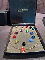 Necklace in tray with cabochon stones and Joan Rivers box visible