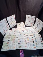 Eight album sheets displayed, each covered with Canadian stamps on envelope fragments