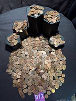 Wide view of bulk coins spread out with several containers showing quantity