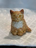 front view of miniature orange cat figurine showing facial detailing and coloration