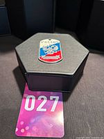 Dog tag pendant displayed on hexagonal box