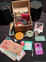 Overview showing box with jewellery, banknotes, pen, cologne bottles and assorted small items
