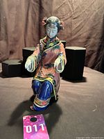 Front view of seated porcelain lady figurine